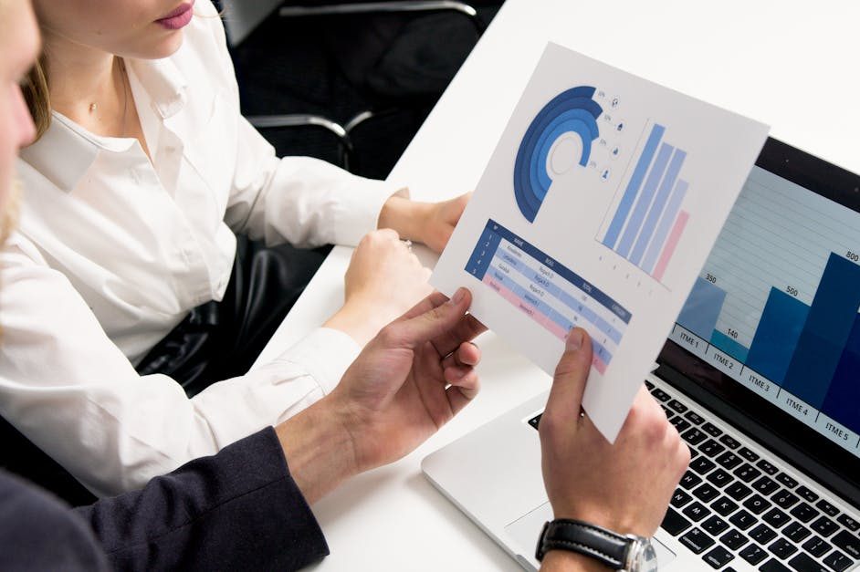 Business professionals discussing data charts and graphs in a modern office setting.